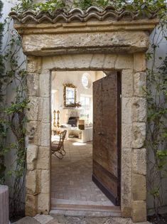 an open door leading to a living room and dining area with ivy growing on the walls