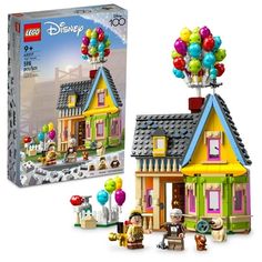 the lego disney house has balloons on it's roof and is next to its box