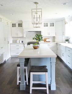 a kitchen island with two stools and a potted plant on top of it