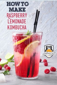 raspberry lemonade kombucha in a glass with strawberries and lime