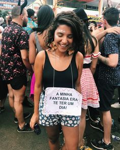 a woman is smiling and holding a sign