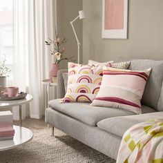 a living room filled with lots of furniture and pillows on top of a gray couch