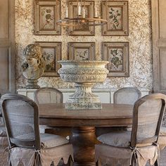 a dining room table with four chairs and a chandelier hanging from the ceiling