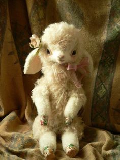 a white stuffed animal sitting on top of a blanket