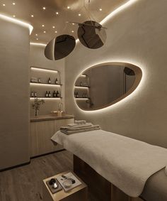 a spa room with white walls and wooden flooring, round mirrors above the massage table