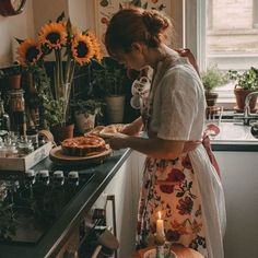 a woman standing in front of a counter preparing food