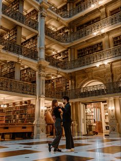 a man and woman standing in front of a library filled with books