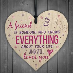 a wooden heart hanging on a wall with the words, friend is someone who knows everything about your life and still loves you