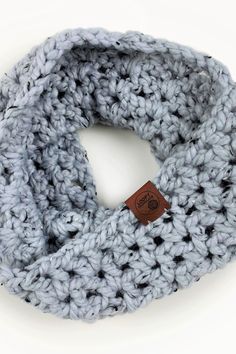 a crocheted scarf with a leather tag on it