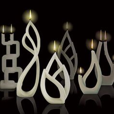 some candles that are in the shape of letters with lights coming out of them on a black background