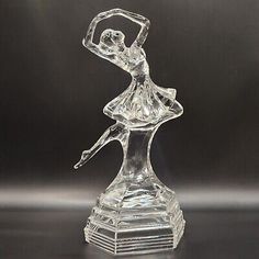 a clear glass figurine with a ballerina figure on it's base