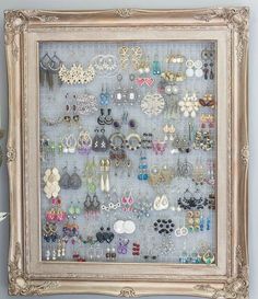 a white frame holding many pairs of earrings