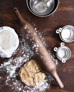 an uncooked cookie on a wooden table next to other baking utensils