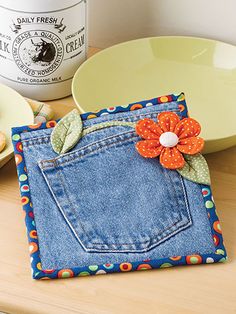 a blue jean pocket sitting on top of a wooden table next to plates and cookies