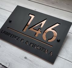 a black and copper house number sign on a white wooden floor with the words law enforcement k & kristena