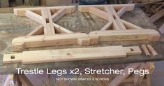 there are some pieces of wood being assembled on the wooden pallet with words reading trestle legs x2, stretcher, pegs and not shown