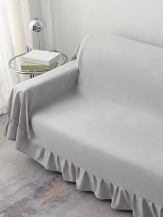 a white couch with a gray cover on it