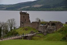 an old castle sits on the edge of a lake