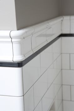 the corner of a white tiled kitchen with black trim