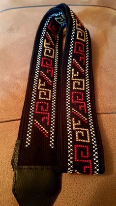 two black ties with red and white designs on them sitting on the floor next to each other