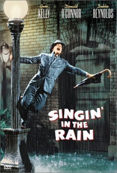 a man is dancing in the rain on a street lamp with his arms stretched out