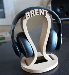 headphones are sitting on top of a wooden stand with the word brent printed on it