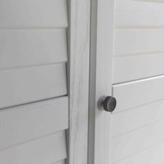 the side of a house with white siding and a black door handle on it's left side