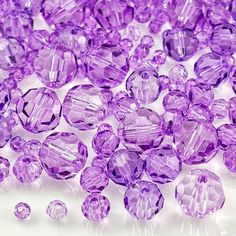 purple crystal beads are scattered on a white surface