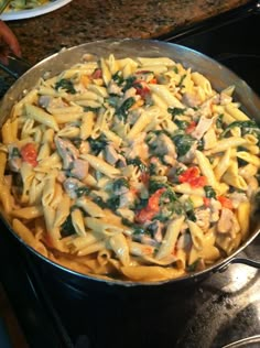 a pan filled with pasta and vegetables on top of a stove