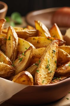 a bowl filled with seasoned potatoes on top of a table