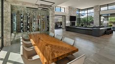 a dining room table with chairs and a wine rack on the wall in front of it