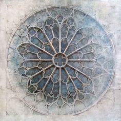 an intricate design on the side of a building's stone wall, with circles in the center