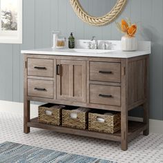 a bathroom vanity with two drawers and a rope hanging above the sink, in front of a blue painted wall