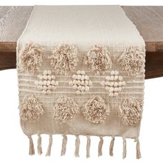 a table runner with tassels and pom - poms on the edge