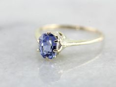 This is a stunning early 1900's green gold engagement ring that has a rich luster! Utterly stunning, this vintage gold piece is lightly chased along the tall, polished shoulders. Green gold is created when gold is alloyed with sterling silver. The center stone of this incredible vintage setting is one of our loveliest sapphires! Blue as an October sky and filled with shine, this amazing stone is a perfect choice for this colorful setting! This ring would be amazing as an engagement ring, or simp Classic Oval Sapphire Ring, Classic Oval Sapphire Ring With Prong Setting, Classic Sapphire Halo Ring, Classic Sapphire Birthstone Ring, Elegant Yellow Gold Sapphire Ring For Wedding, Antique 14k Gold Solitaire Jewelry, Antique Yellow Gold Sapphire Ring For Anniversary, Timeless Yellow Gold Sapphire Ring With Center Stone, Heirloom Solitaire Sapphire Promise Ring