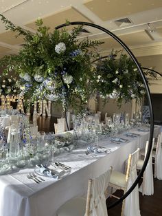 the table is set with white and blue flowers