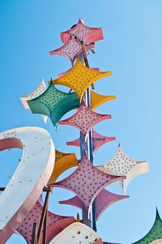 a large metal sculpture with many different colored stars on it's top and bottom