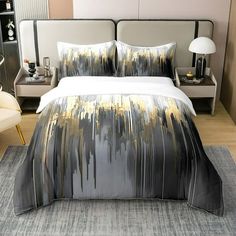 a bedroom with a large bed covered in grey and gold sheets