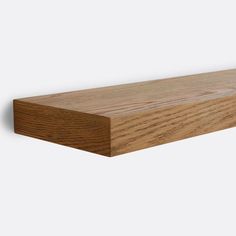 a close up of a wooden shelf on a white wall with no one around it