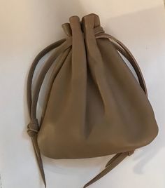 "This leather drawstring pouch bag is so soft and supple and will only get better with age. Made using Italian Lambskin leather.  This leather is hand selected to ensure you are getting the very best quality when I make my products. Color - Taupe Large Pouch - Over all size approx -  6 1/2\" H X 5 1/2\" W.Pull draw string to close at top. Back to shop - http://www.etsy.com/shop/shirlbcreationstoo Read Customer Reviews from Shirlbcreationstoo customers here: http://www.etsy.com/people/oneredindia Leather Drawstring Pouch, Medicine Pouch, Pouch Bags, Medicine Bag, Grey Bag, Large Pouch, Sack Bag, Coin Bag, Purple Leather