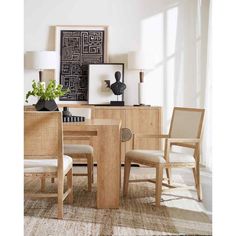 a dining room table with chairs and pictures on the wall