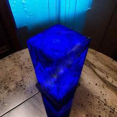 a blue plastic container sitting on top of a table next to a door and window