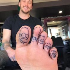 a man with tattoos on his fingers and feet