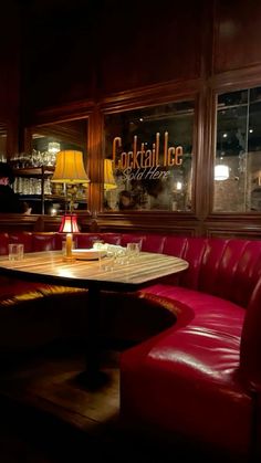 a red leather couch sitting in front of a wooden table