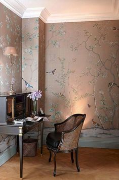 a chair and desk in front of a wallpapered room with birds on it