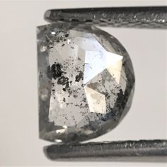 a close up view of a diamond on a piece of metal with some dirt around it