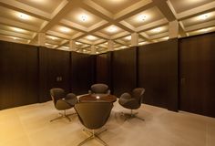 an empty conference room with several chairs and lights on the ceiling is lit by recessed lighting