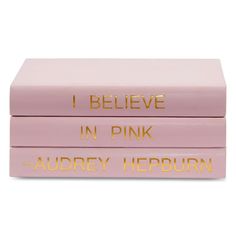 three pink books with gold lettering on them