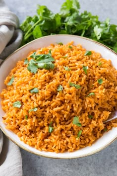 mexican rice with cilantro and parsley in a white bowl on a gray surface