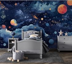 a child's bedroom with an outer space theme painted on the wall and furniture